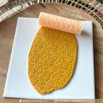 Massa mostarda com padrão gravado em base branca com rolo de textura alaranjado em cima