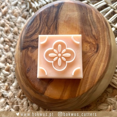 Cortador quadrado com padrão floral salmão em prato de madeira