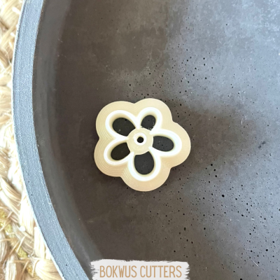 Cortante de massa branco em forma de flor dentro de tigela cinza