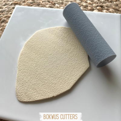 Ferramentas para corte e texturização com peça bege texturizada e rolo cinza