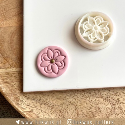 Cortante plástico branco com padrão floral e massa rosa com relevo floral