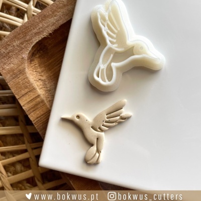 Cortador de biscoitos em forma de beija-flor com biscoito e fundo de madeira