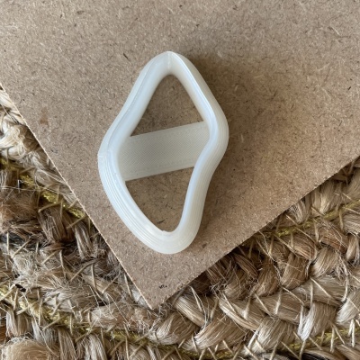 Anilha plástica branca em superfície de cartão e tecido trançado