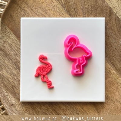 Cortador de biscoitos em forma de flamingo e biscoito sobre superfície branca