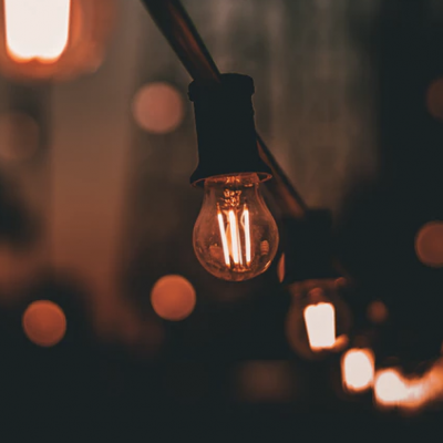 Lâmpadas de filamento penduradas com luzes amarelas em ambiente escuro