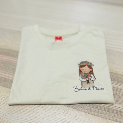 T-shirt branca com estampa de rapariga e texto 'Borboleta de Música'