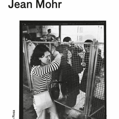 Capa do livro Um Sétimo Homem de John Berger e Jean Mohr com fotografia a preto e branco de uma mulher junto a uma vedação de metal.