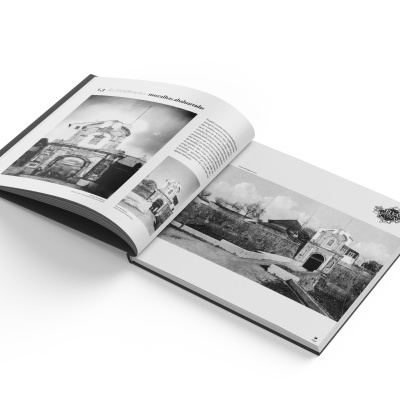 Livro aberto com fotografias a preto e branco de construções históricas e textos em português