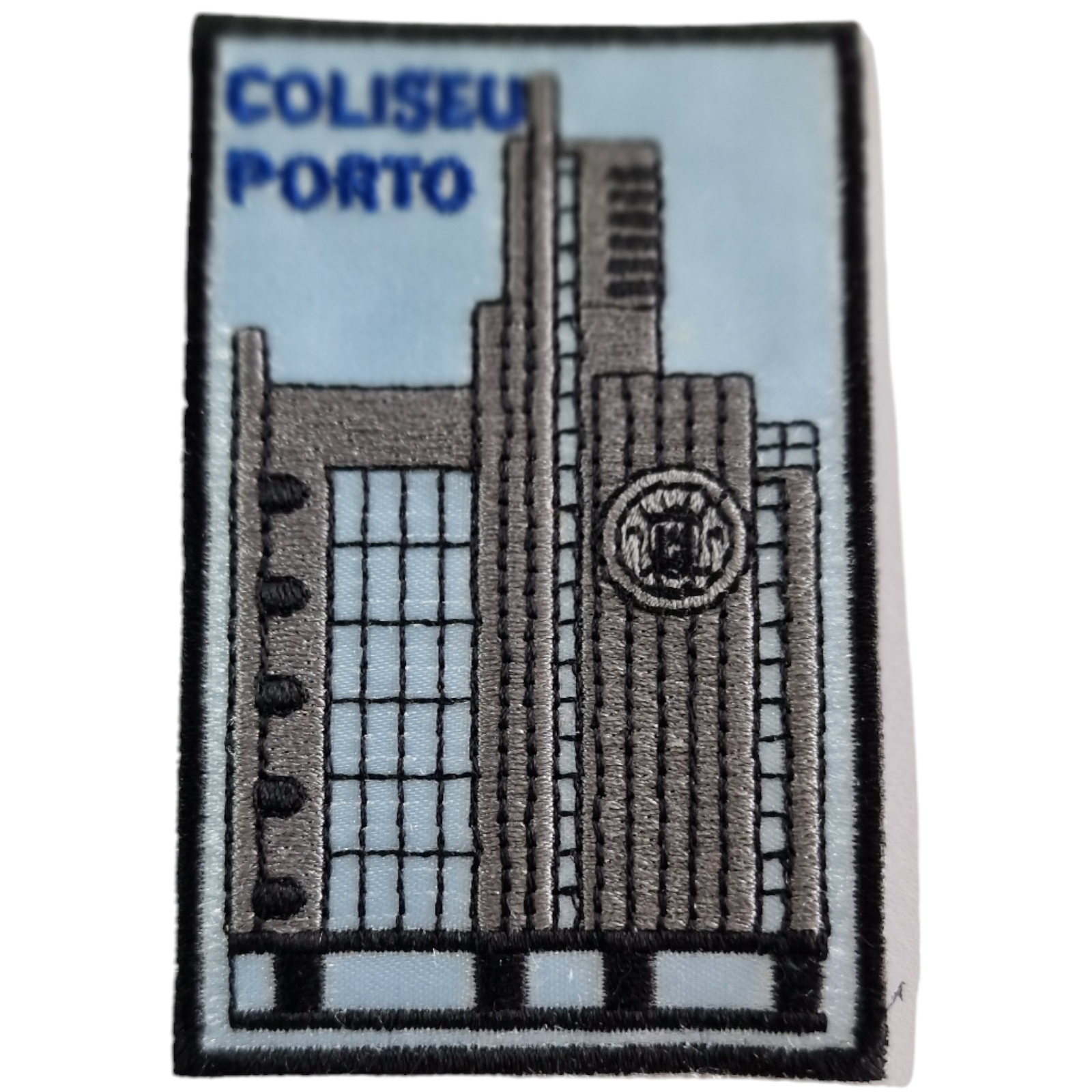 Emblema bordado do edifício Coliseu Porto em tons cinza e azul