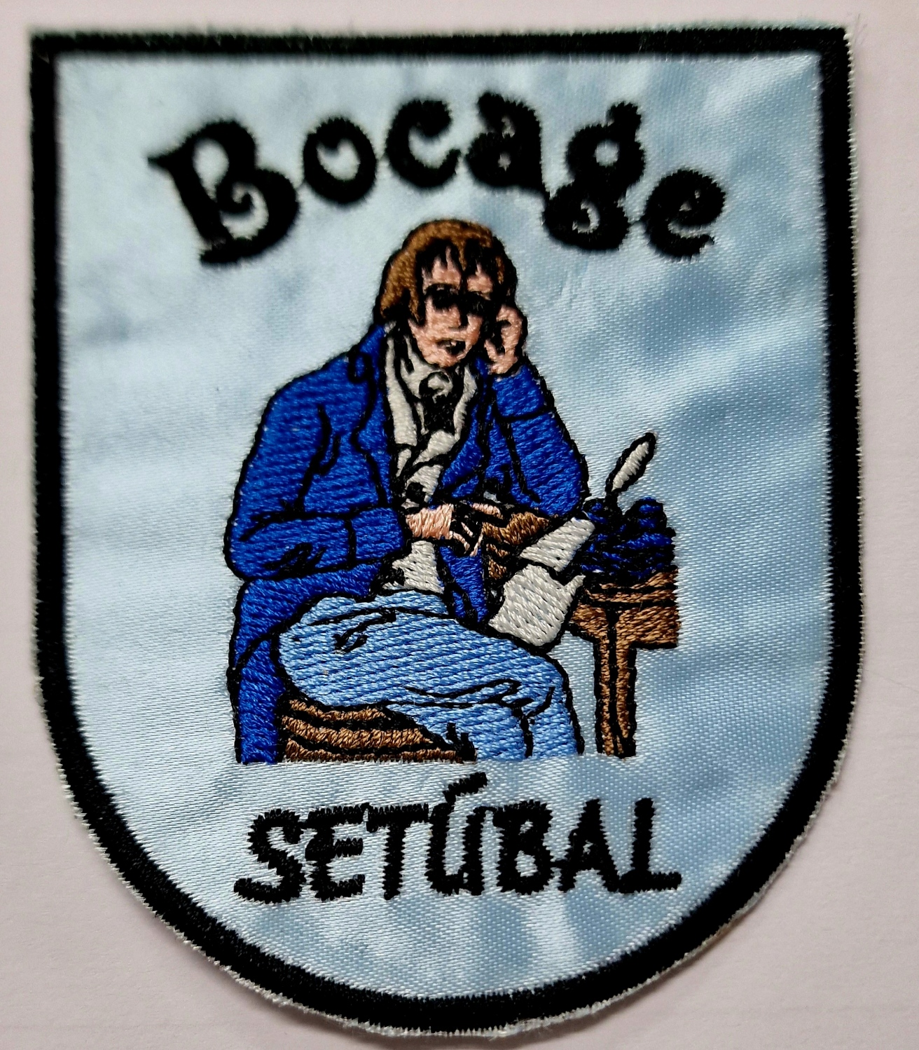 Emblema bordado com guarda-redes e texto Bocage Setúbal em fundo azul claro