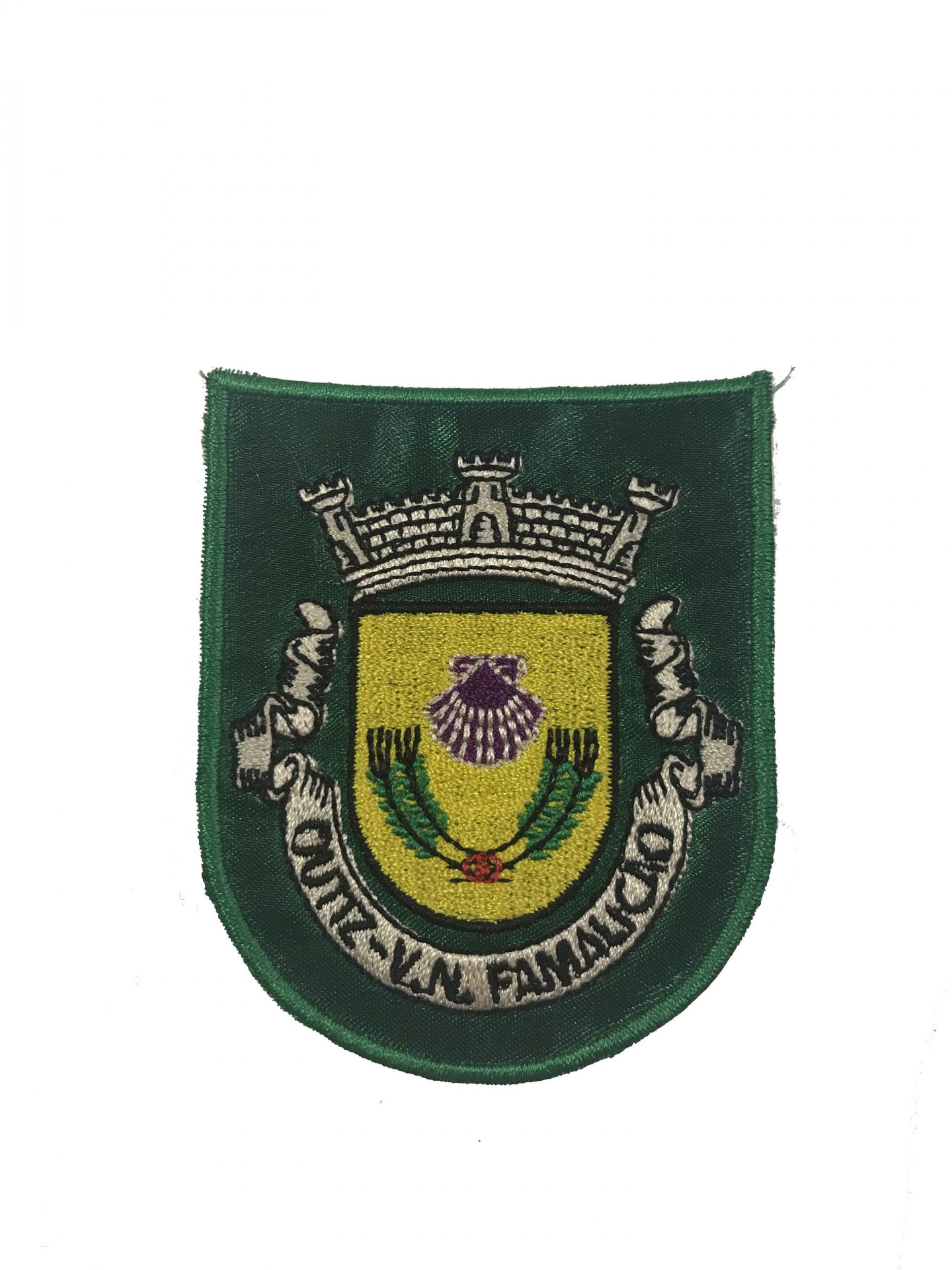 Emblema bordado verde escuro com escudo amarelo, concha roxa, ramos verdes, coroa cinza e texto MUN. DE V.N. FAMALICÃO