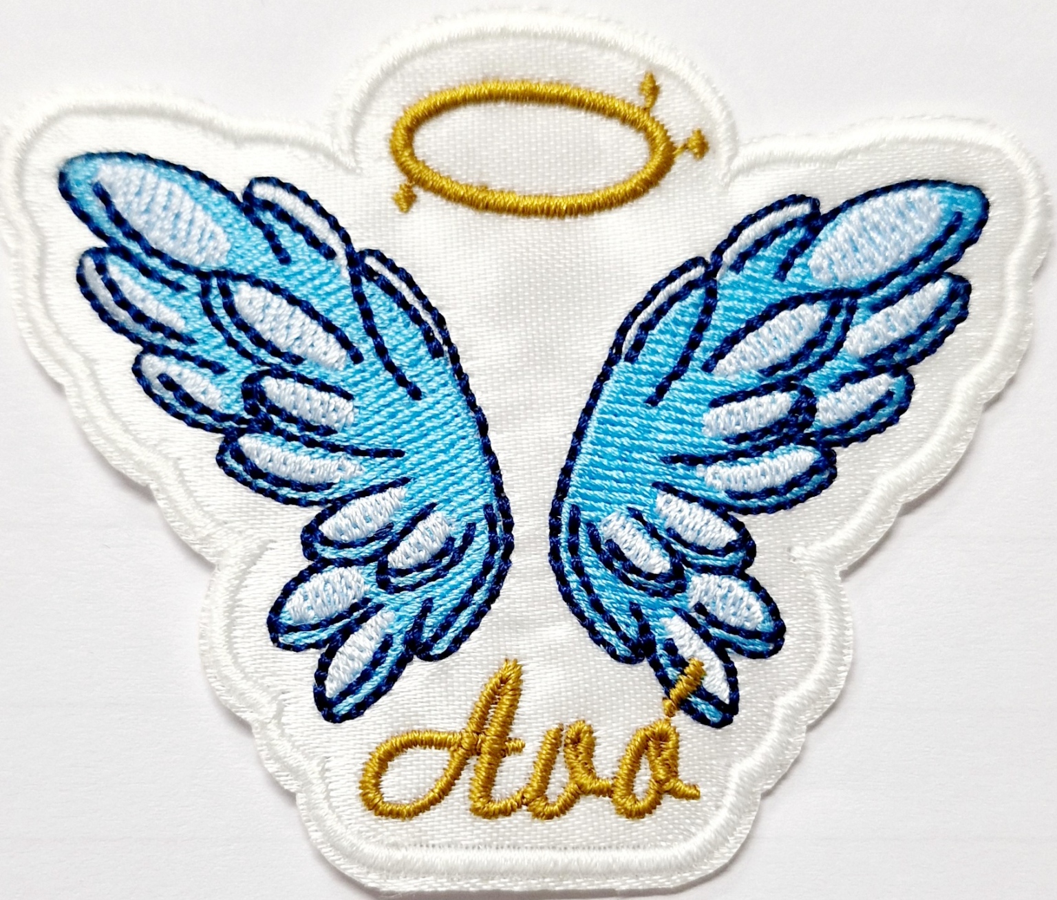 Emblema bordado com asas azuis, auréola dourada e texto 'Avó'.