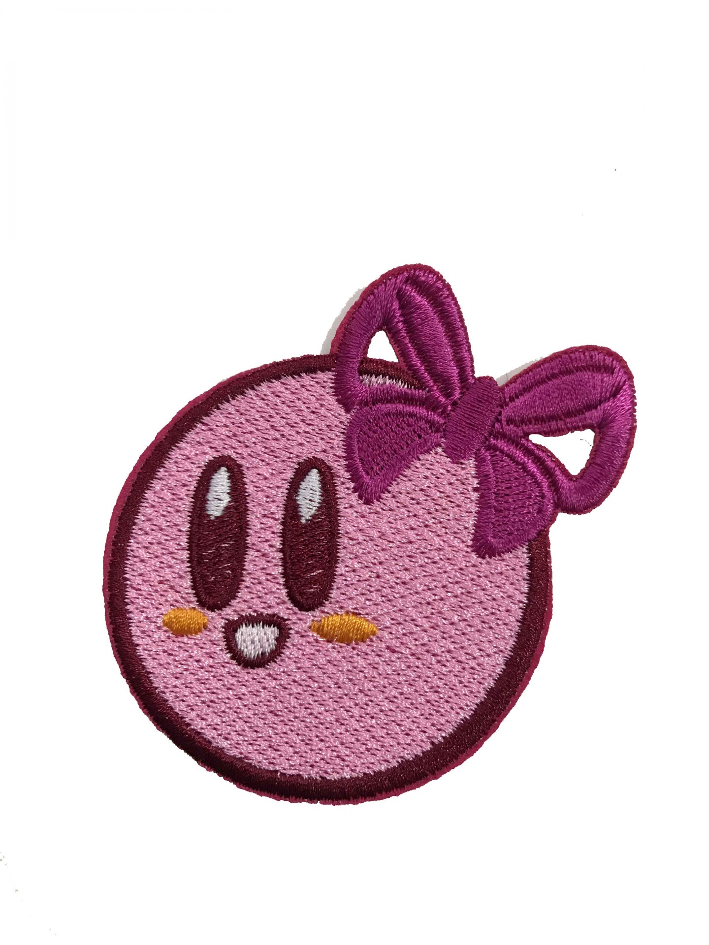 Emblema bordado cor-de-rosa com rosto sorridente e laço roxo