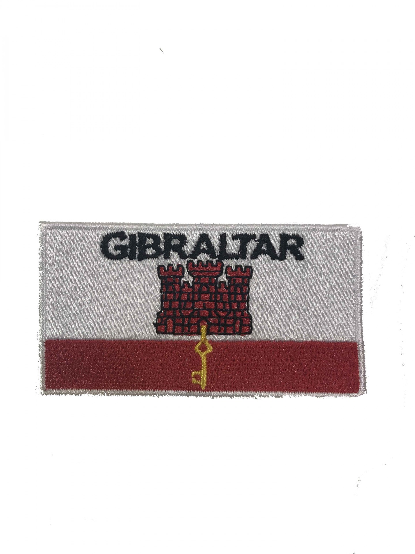 Patch bordado com a palavra GIBRALTAR, castelo vermelho e chave amarela em fundo branco e vermelho