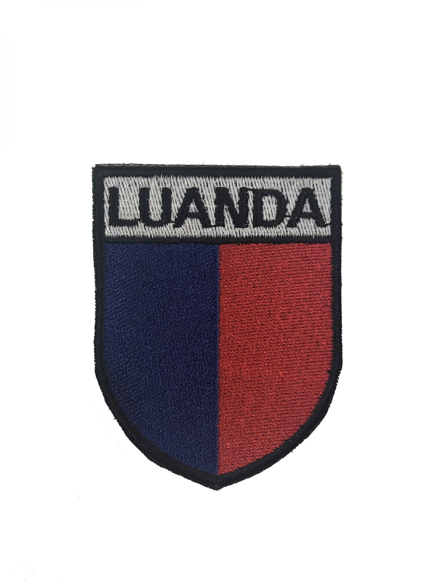 Emblema bordado em formato de escudo com as cores azul, vermelho e cinzento e texto LUANDA
