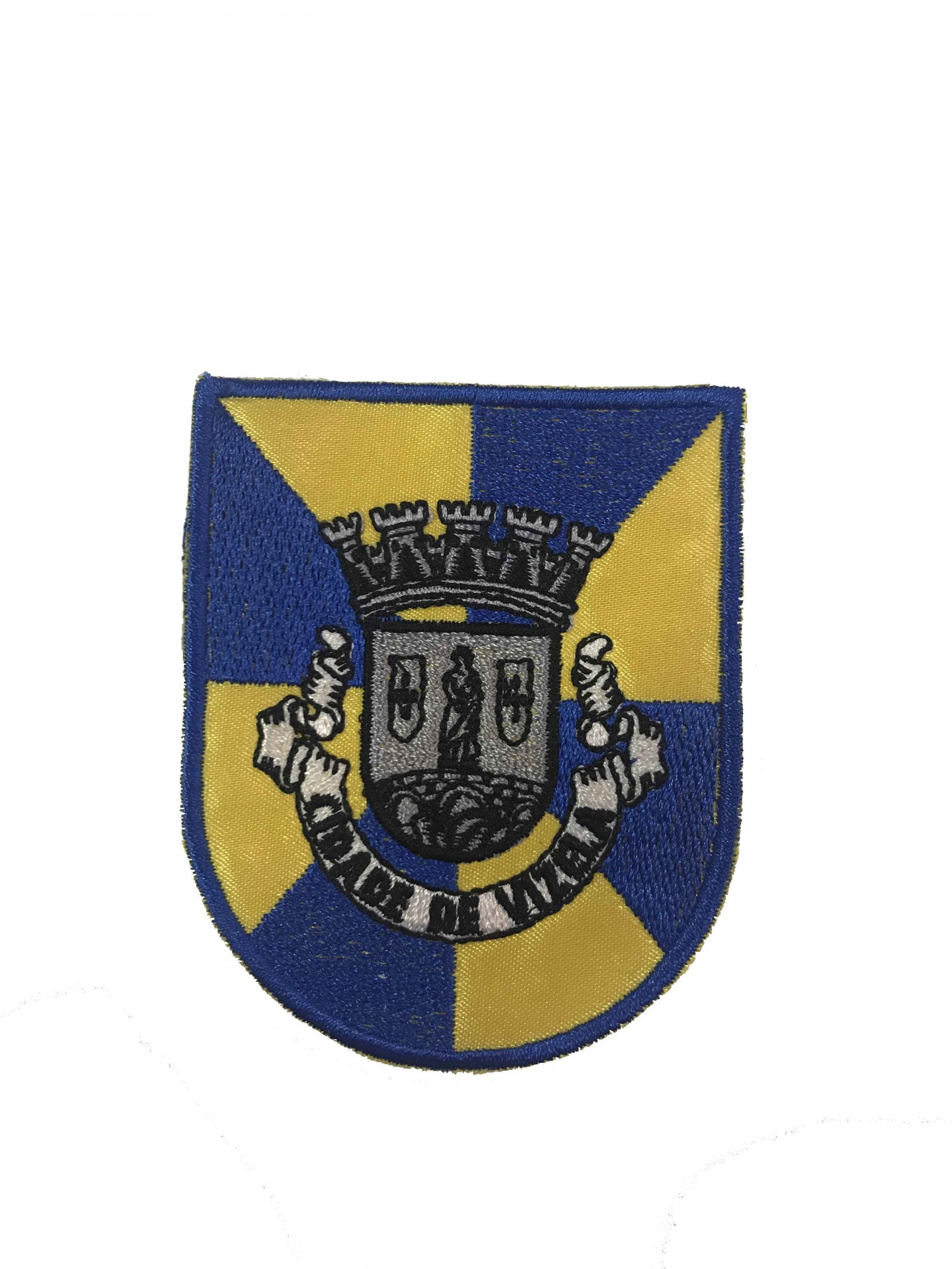 Emblema bordado com escudo azul e amarelo e brasão central cinza.