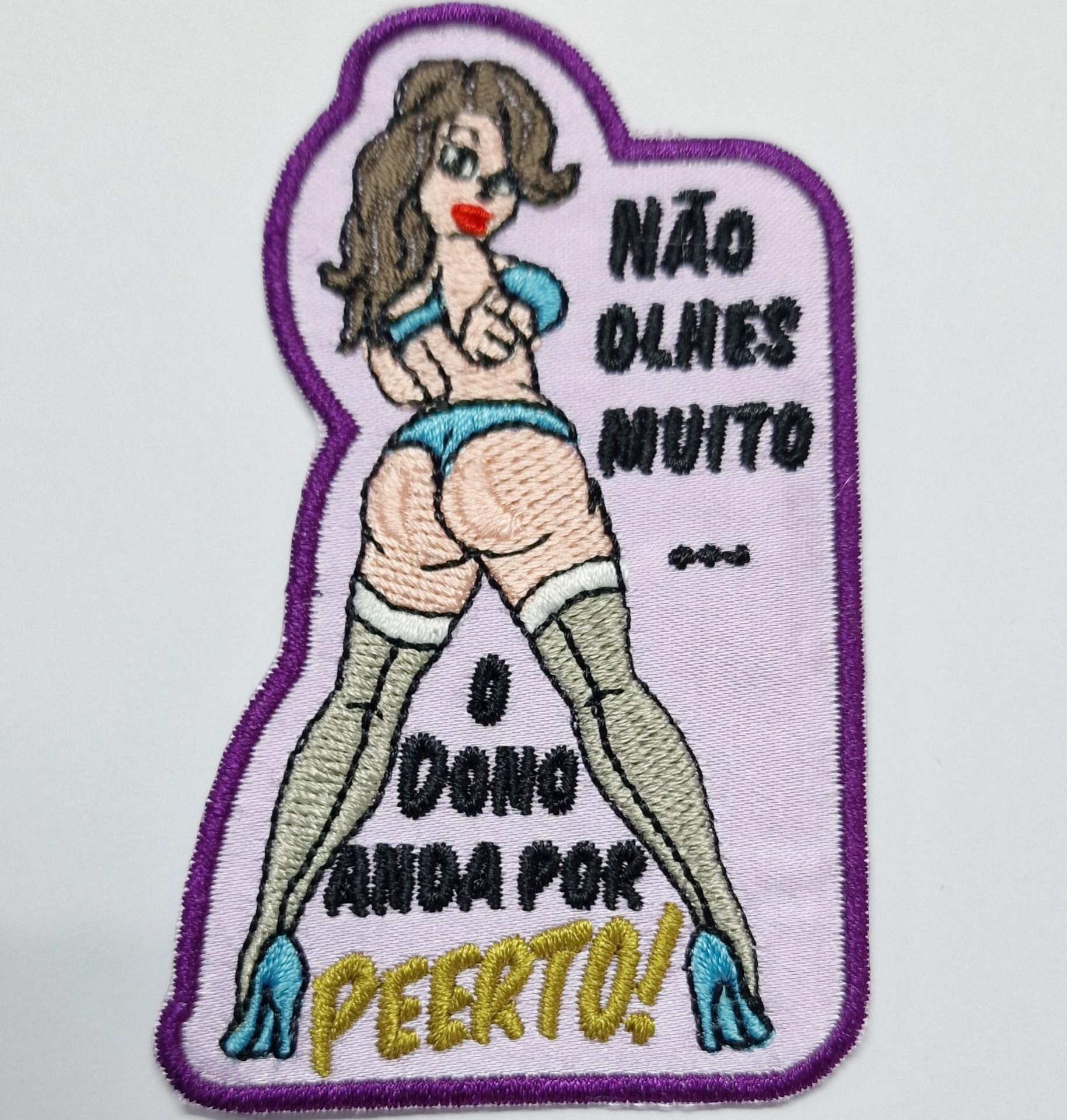 Emblema bordado com mulher e texto humorístico em português