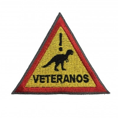 Emblema triangular bordado com dinossauro e texto ¡VETERANOS