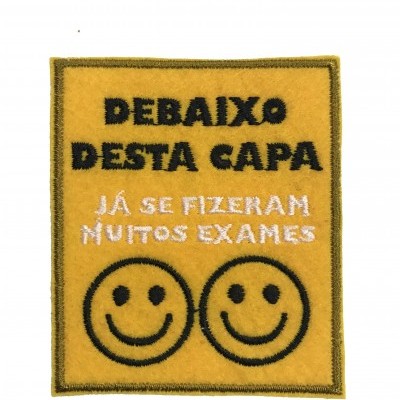 Peça de feltro amarelo com texto bordado e dois rostos sorridentes