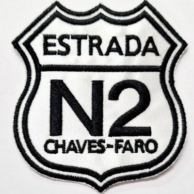 Emblema bordado preto e branco com texto ESTRADA N2 CHAVES-FARO