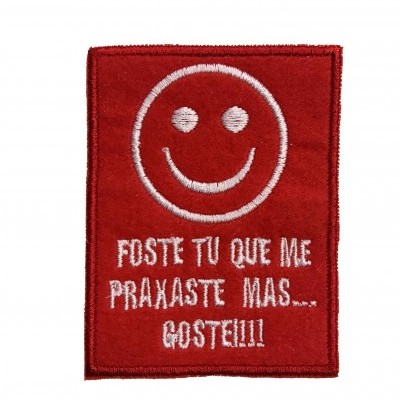 Patch bordado vermelho com rosto sorridente e texto em branco.
