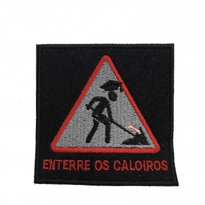Patch bordado com figura de pessoa a cavar e texto 'ENTERRE OS CALOIROS'
