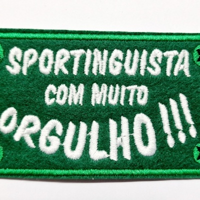 Patch retangular verde com texto branco SPORTINGUISTA COM MUITO ORGULHO !!! e olhos de cruz preta nos cantos