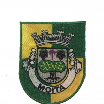 Emblema bordado em forma de escudo com cores verde, amarelo, e detalhes em cinza, roxo e amarelo