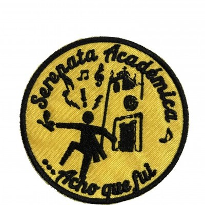 Emblema redondo amarelo com texto e figura preta de pessoa com guizos