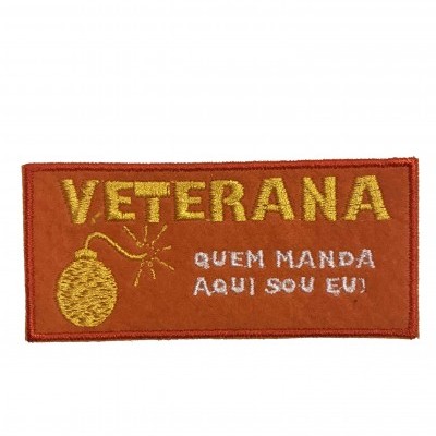 Etiqueta bordada retangular com texto VETERANA e frase QUEM MANDA AQUI SOU EU!