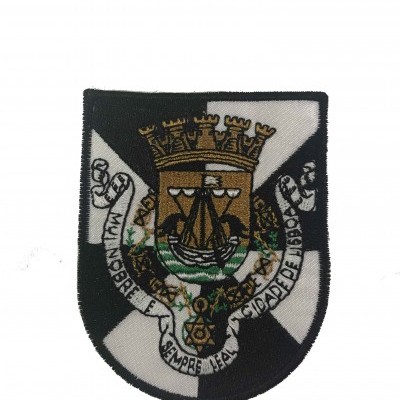 Emblema bordado com escudo e texto sobre fundo branco.