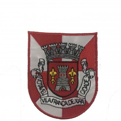 Emblema tecido vermelho e branco com brasão, torre, flores de lis amarelas e texto Vila Franca de Xira