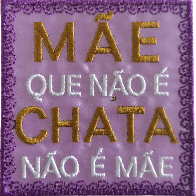 Quadrado de tecido lilás bordado com texto em amarelo e branco