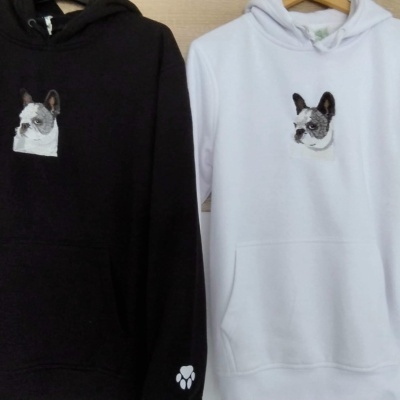 Duas sweatshirts com capuz, preta e branca, com estampa de cão e pata na manga