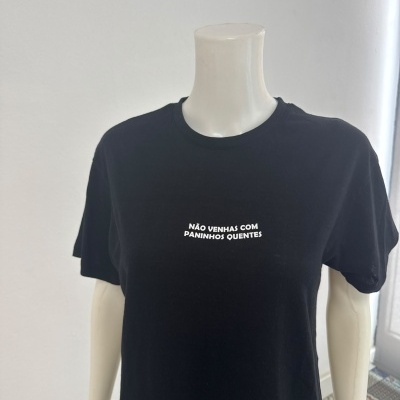 T-shirt preta com texto branco NÃO VENHAS COM PANINHOS QUENTES num manequim branco