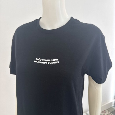 T-shirt preta com mensagem branca em manequim branco