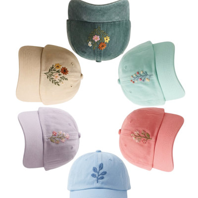 Seis bonés coloridos com bordados florais em círculo sobre fundo branco