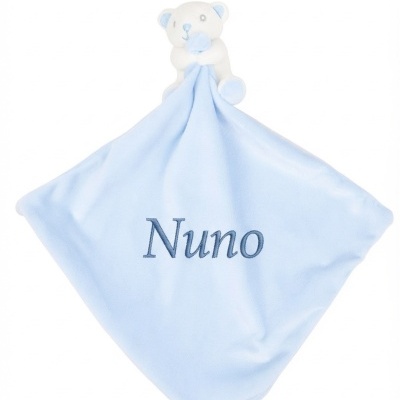 Manta azul clara com ursinho branco e azul preso no topo e nome Nuno bordado.