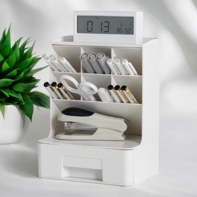 Organizador de secretária branco com canetas, tesoura, grampeador e relógio digital