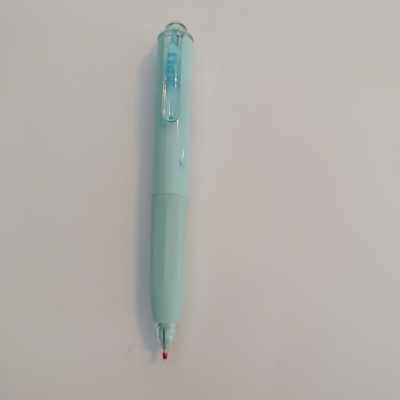 Caneta azul clara com ponta vermelha sobre fundo branco