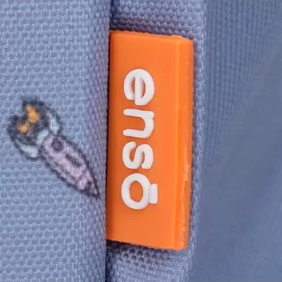 Etiqueta laranja com texto 'ensa' em tecido azul com padrão de foguete