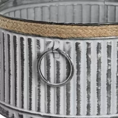 Contentor cilíndrico em metal cinza envelhecido com riscas e corda de sisal na borda, argola metálica lateral