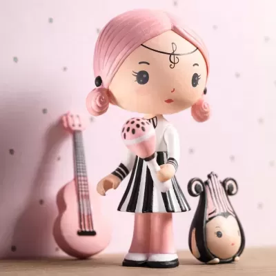 Figura de menina com maraca e dois instrumentos musicais em cerâmica resina.