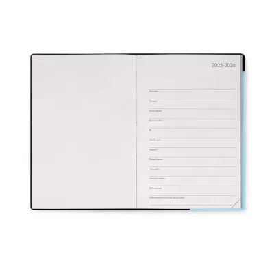 Agenda ou caderno aberto com capa preta e página de dados pessoais para 2025-2026