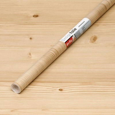 Rolo de papel autocolante decorativo efeito madeira clara numa superfície de madeira.