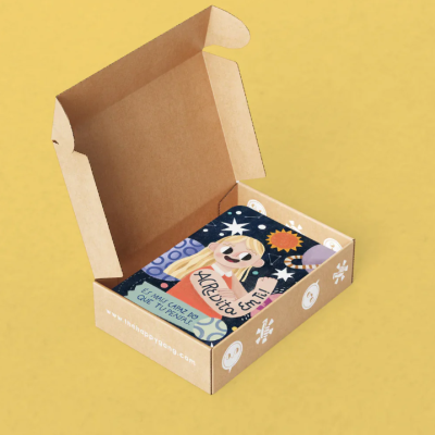 Caixa de cartão aberta com livro ilustrado dentro