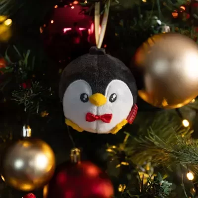 Enfeite de Natal pinguim pelúcia com bolas douradas e vermelhas na árvore