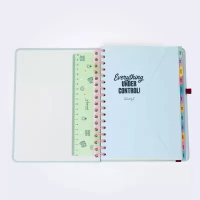 Caderno espiralado azul claro com texto 'Everything UNDER CONTROL!' e separadores de meses coloridos.