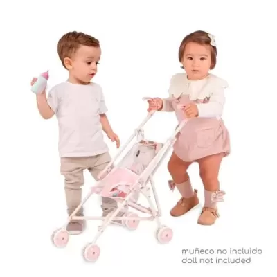 Duas crianças pequenas com roupa casual e um carrinho cor-de-rosa para bonecas com um ursinho à frente.