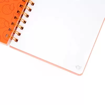 Caderno espiral laranja com página branca e desenho pequeno no canto.